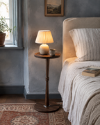 Alden Pedestal Side Table beside a cozy blue bedroom