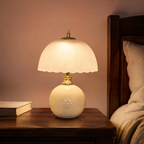 Nori cream ceramic globe lamp with scalloped ivory shade, brass neck and floral applique